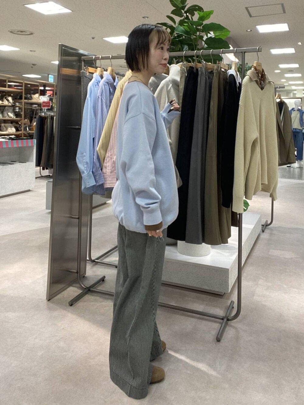 ブルー系のその他パンツ、ベージュ系のトレンチコート、ブラウン系のスニーカーを着用したレディースの冬コーディネートの5枚目の写真