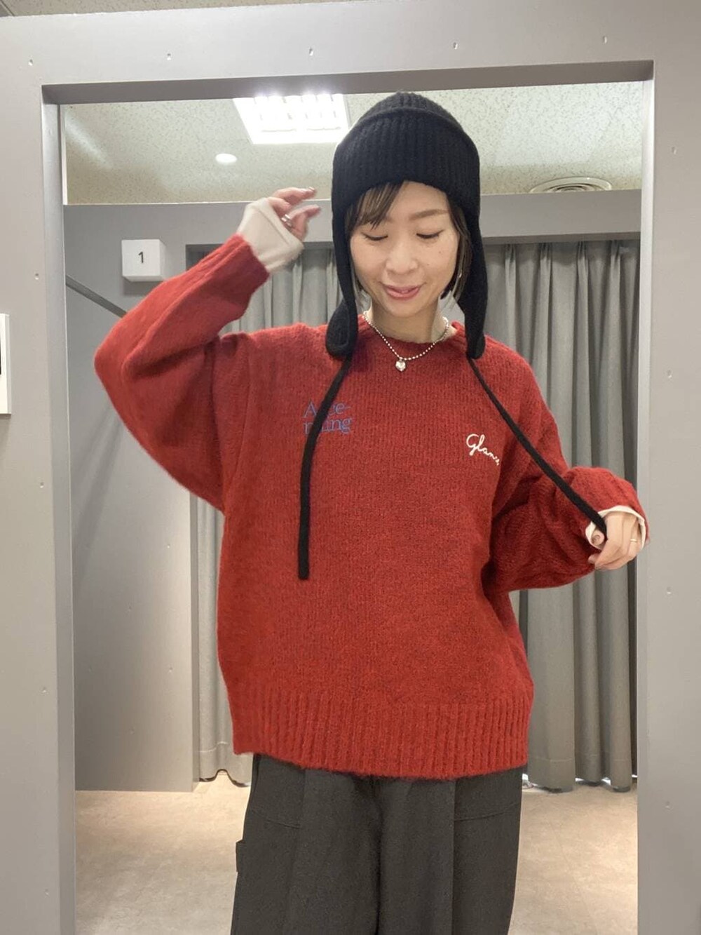 グレー系のその他パンツ、ホワイト系のTシャツ/カットソー、レッド系のニット/セーターを着用したレディースの冬コーディネートの4枚目の写真