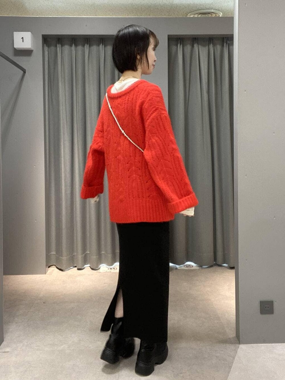 ホワイト系のTシャツ/カットソー、ブラック系のスカート、ブラック系のブーツを着用したレディースの冬コーディネートの3枚目の写真