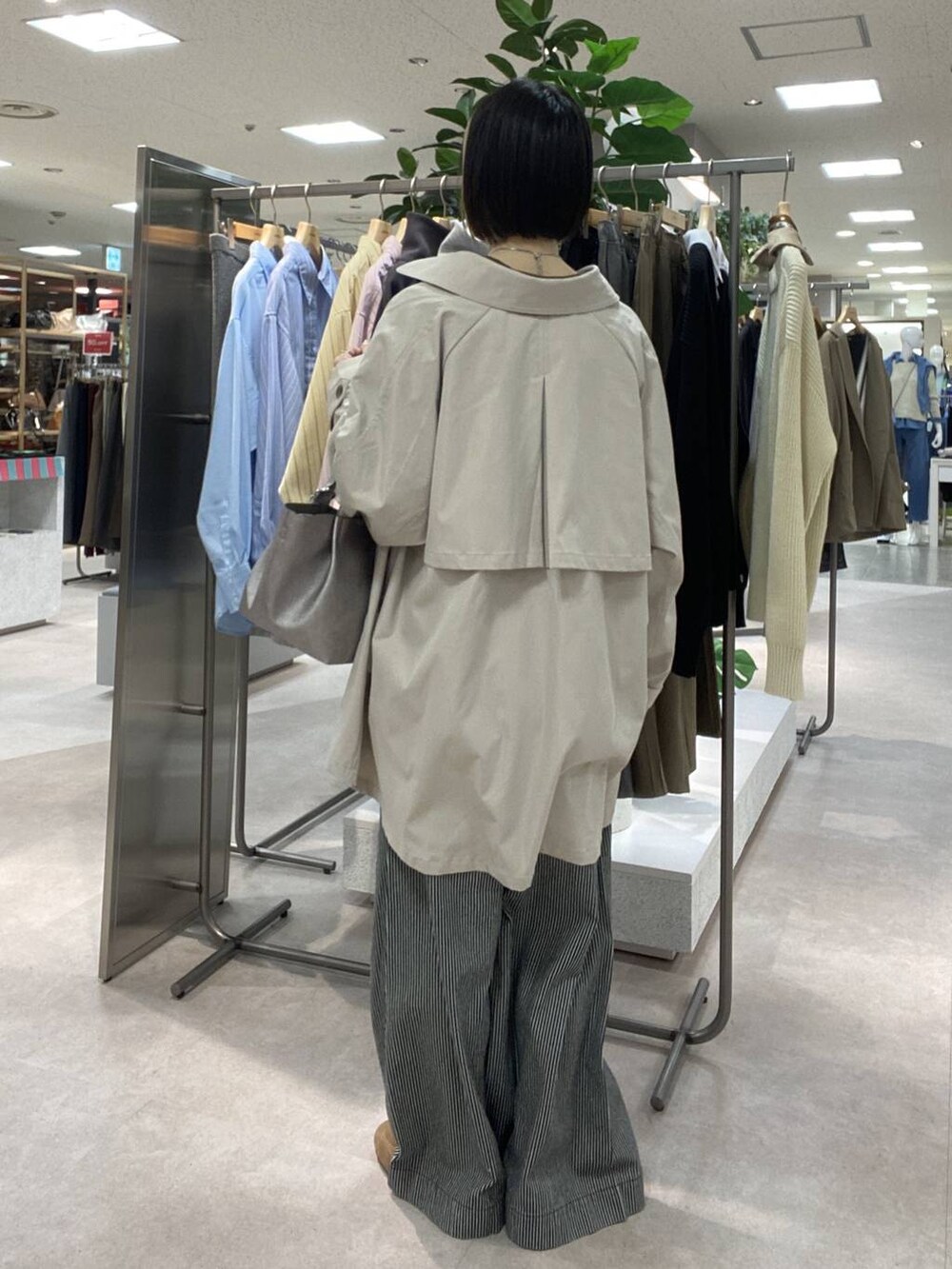 ブルー系のその他パンツ、ベージュ系のトレンチコート、ブラウン系のスニーカーを着用したレディースの冬コーディネートの3枚目の写真