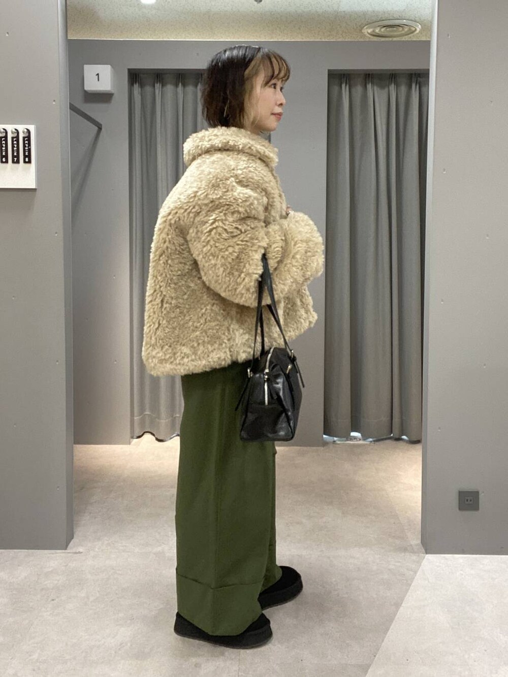 ブラック系のボストンバッグ、グリーン系のその他パンツ、ベージュ系のブルゾンを着用したレディースの秋コーディネートの3枚目の写真