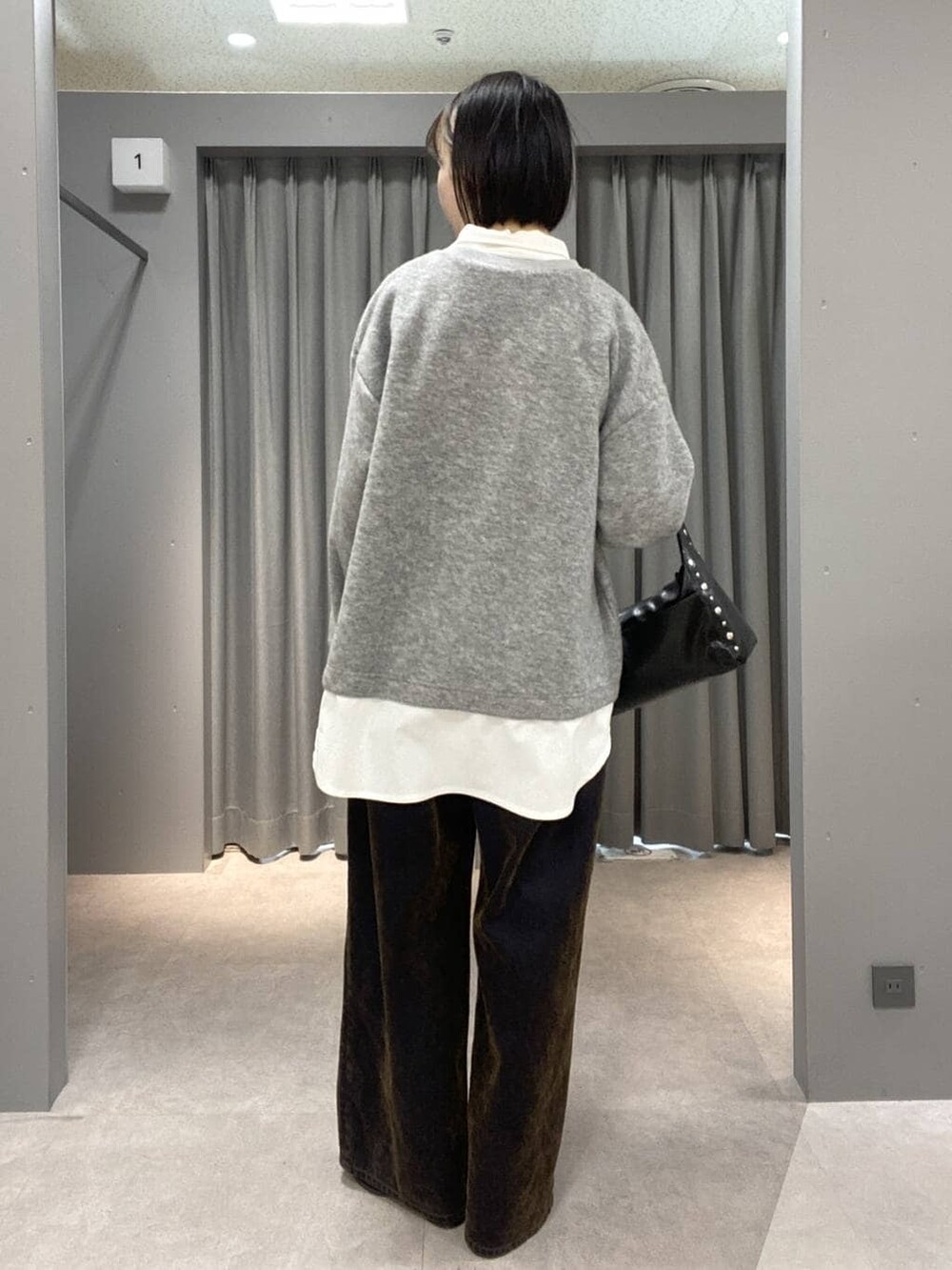 ブラック系のブーツ、ブラック系のハンドバッグ、グレー系のTシャツ/カットソーを着用したレディースの冬コーディネートの3枚目の写真