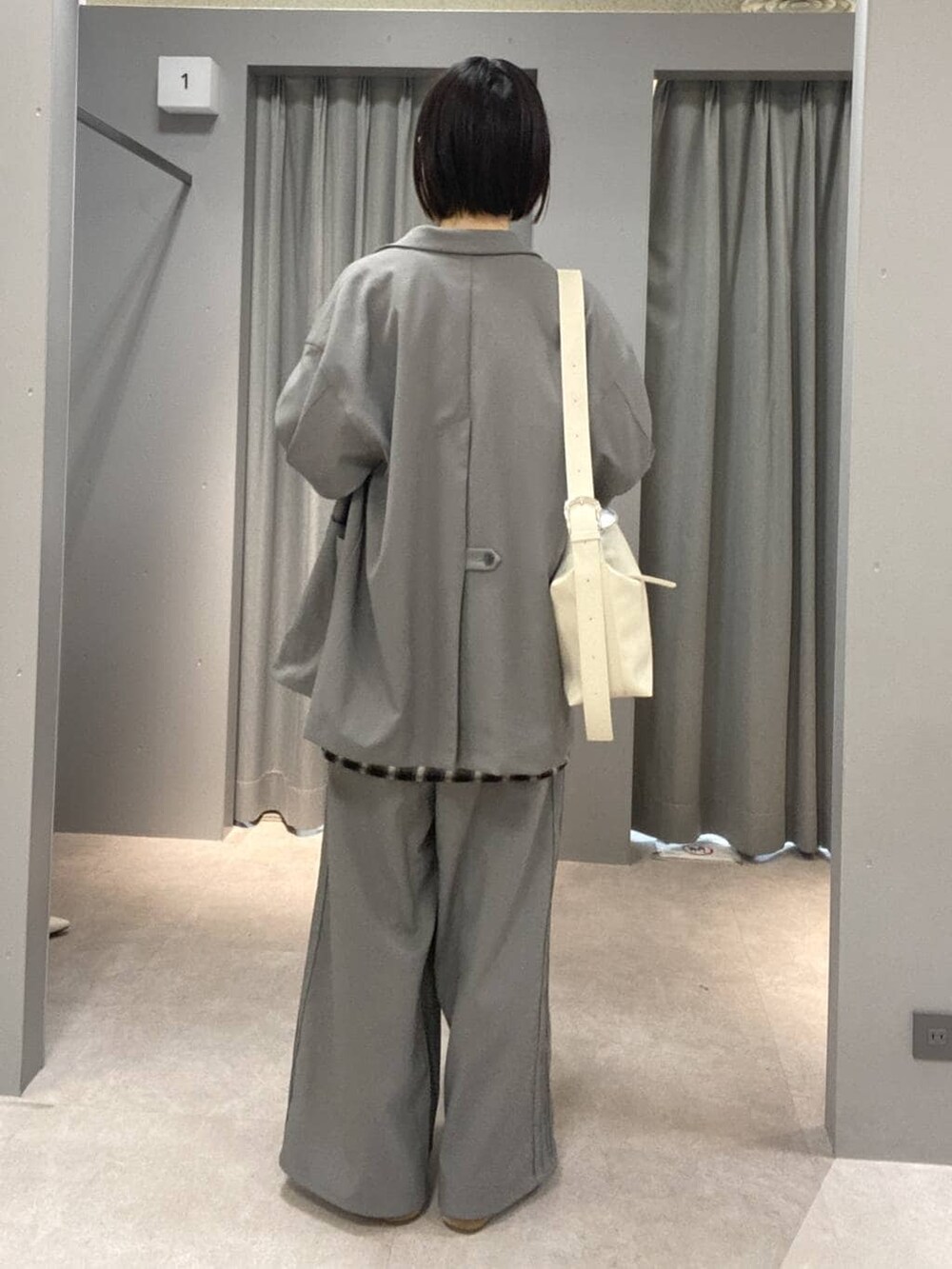 ホワイト系のショルダーバッグ、グレー系のその他パンツ、グレー系のテーラードジャケットを着用したレディースの冬コーディネートの4枚目の写真