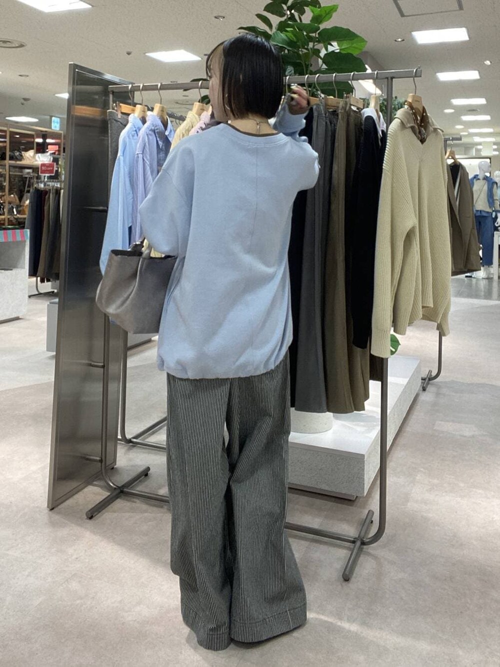 ブルー系のその他パンツ、ベージュ系のトレンチコート、ブラウン系のスニーカーを着用したレディースの冬コーディネートの6枚目の写真
