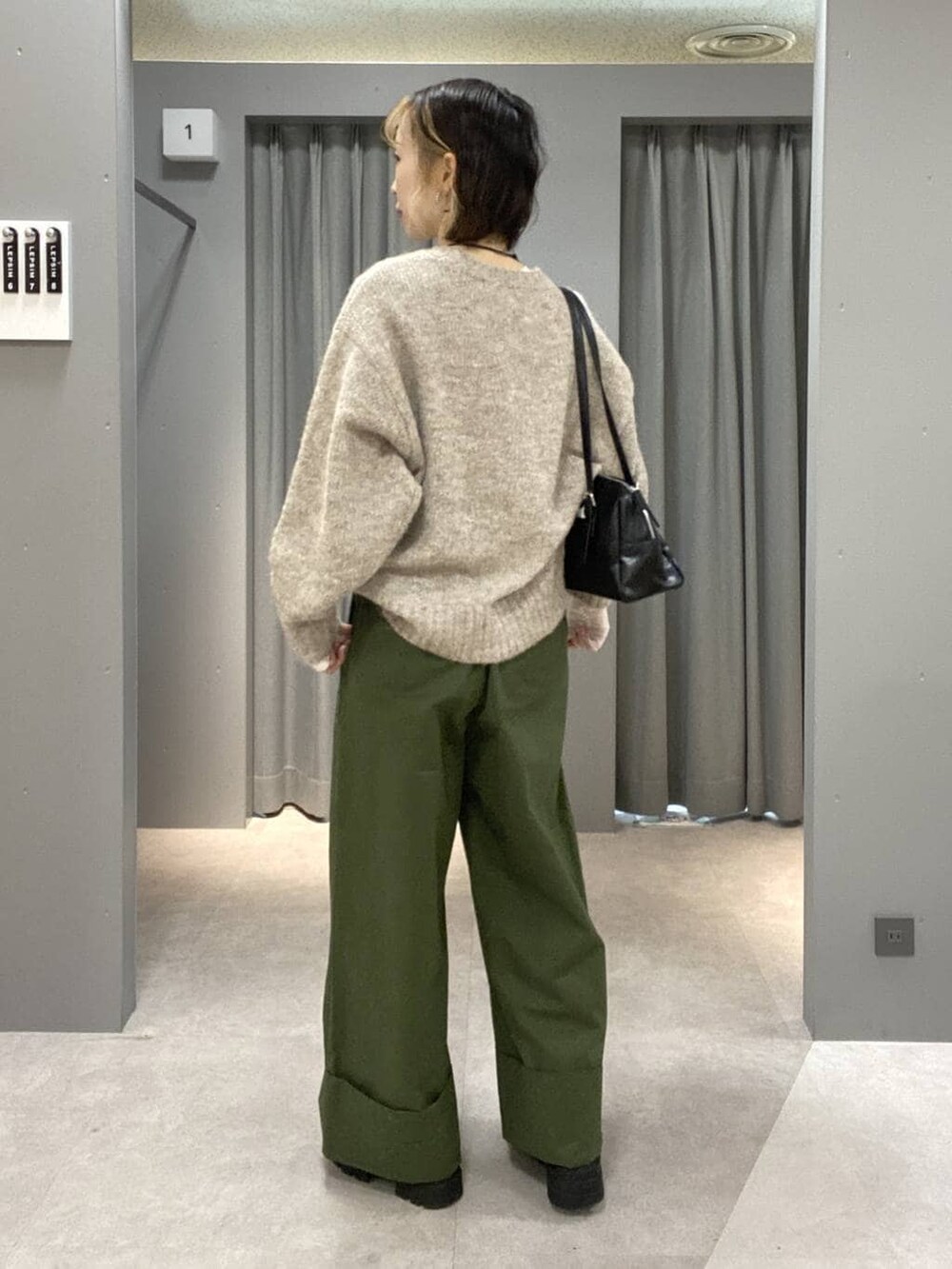ブラック系のボストンバッグ、グリーン系のその他パンツ、ベージュ系のニット/セーターを着用したレディースの秋コーディネートの3枚目の写真