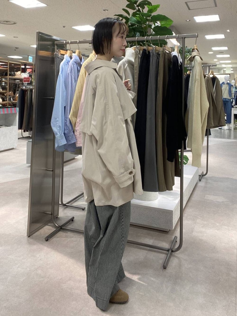 ブルー系のその他パンツ、ベージュ系のトレンチコート、ブラウン系のスニーカーを着用したレディースの冬コーディネートの2枚目の写真