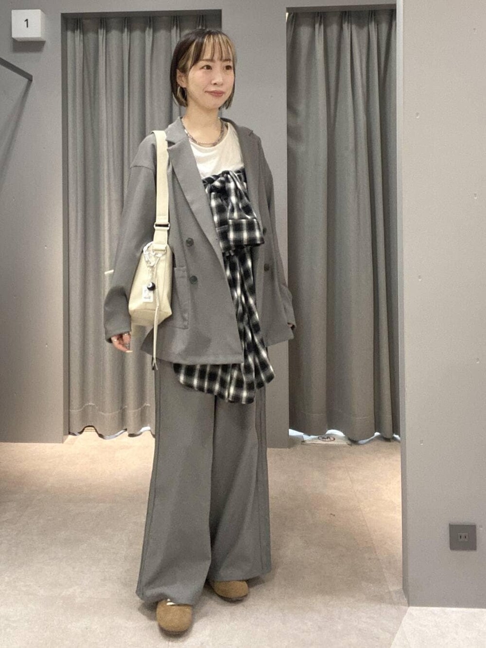 ホワイト系のショルダーバッグ、グレー系のその他パンツ、グレー系のテーラードジャケットを着用したレディースの冬コーディネートの2枚目の写真