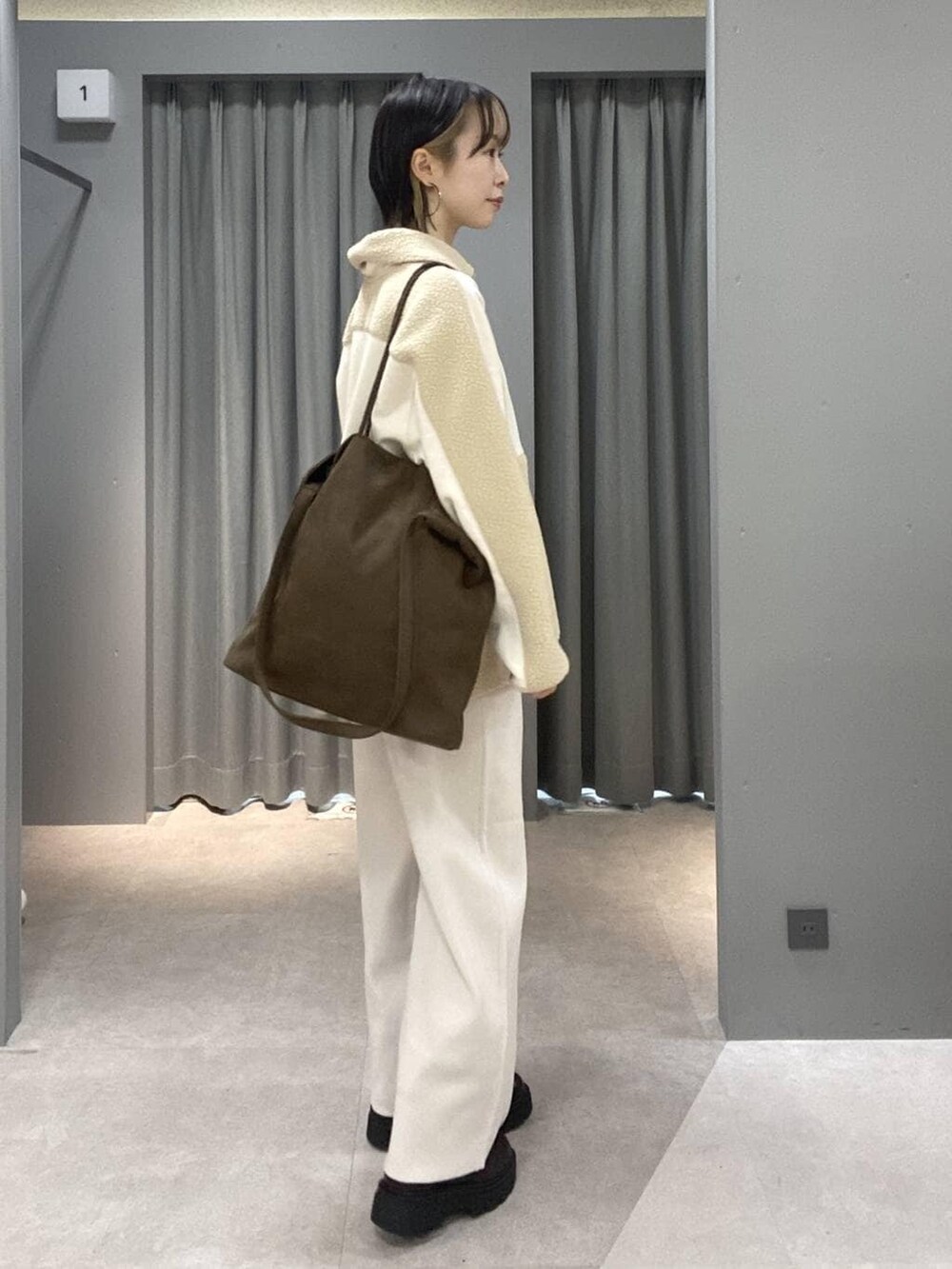 ベージュ系のその他パンツ、ブラウン系のトートバッグ、シルバー系のネックレスを着用したレディースの秋コーディネートの2枚目の写真
