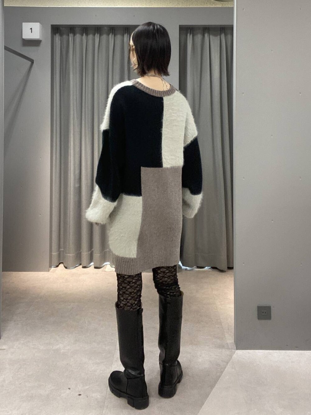ブラック系のブーツ、ブラック系のショルダーバッグ、グレー系のニット/セーターを着用したレディースの秋コーディネートの6枚目の写真