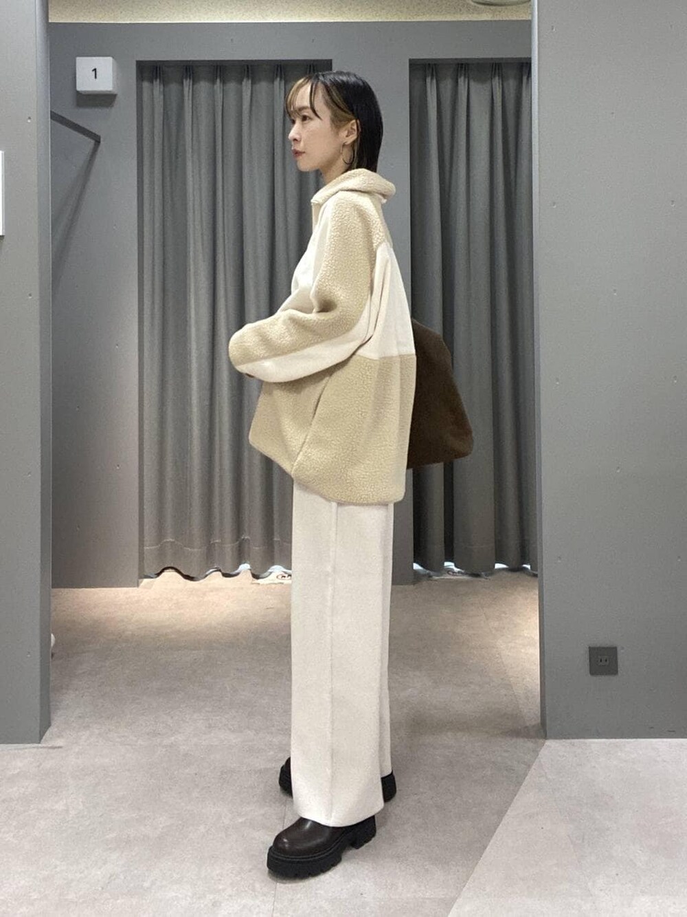 ベージュ系のその他パンツ、ブラウン系のトートバッグ、シルバー系のネックレスを着用したレディースの秋コーディネートの4枚目の写真