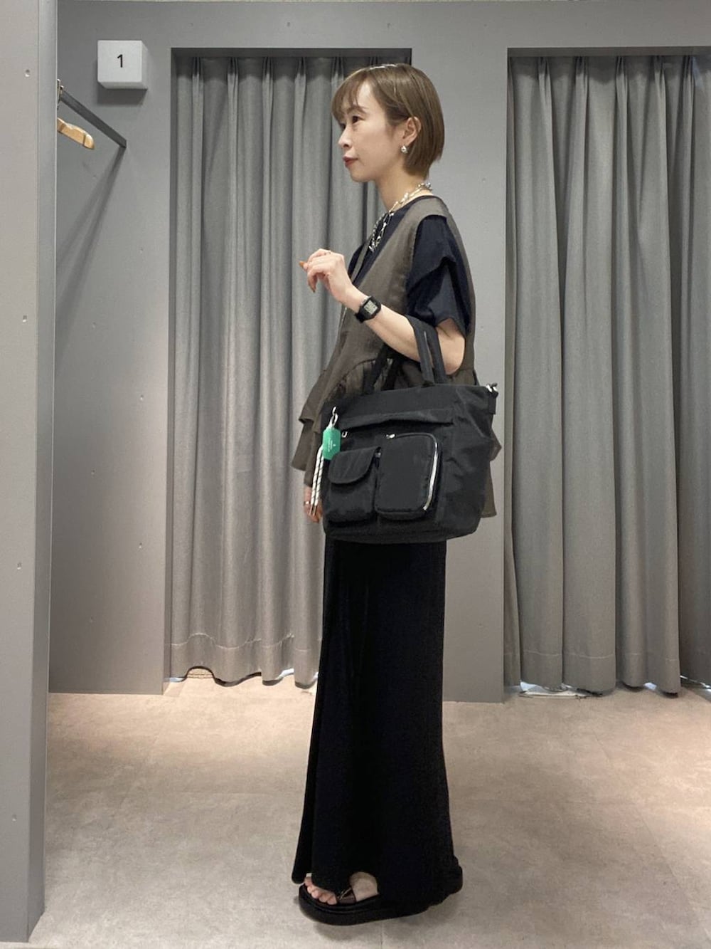 ブラック系のスカート、ブラック系のトートバッグ、ブラック系のサンダルを着用したレディースの夏コーディネートの2枚目の写真