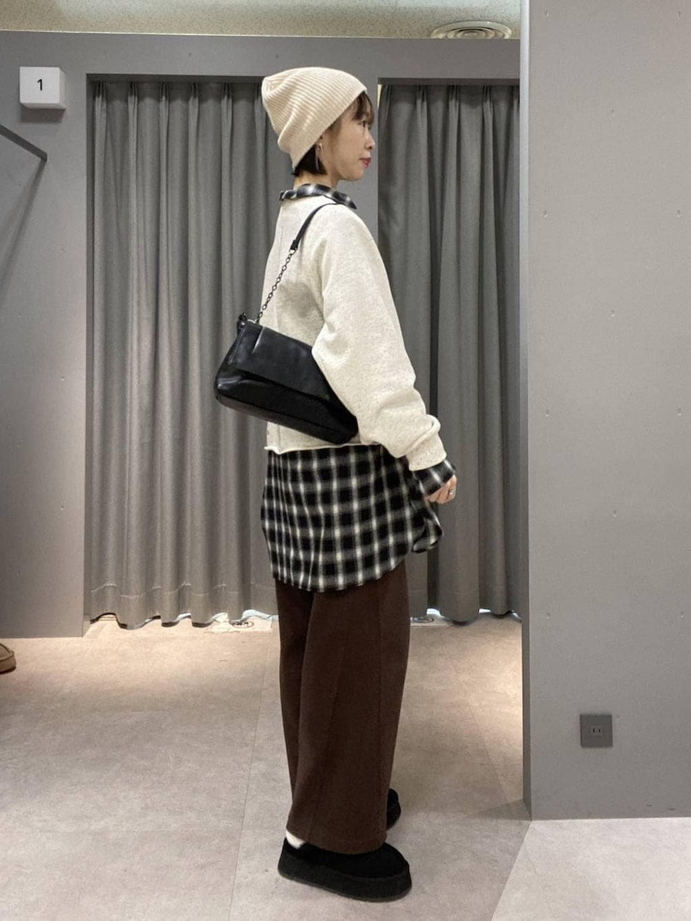 ブラウン系のその他パンツ、ブラック系のその他シューズ、ブラック系のショルダーバッグを着用したレディースの冬コーディネートの2枚目の写真