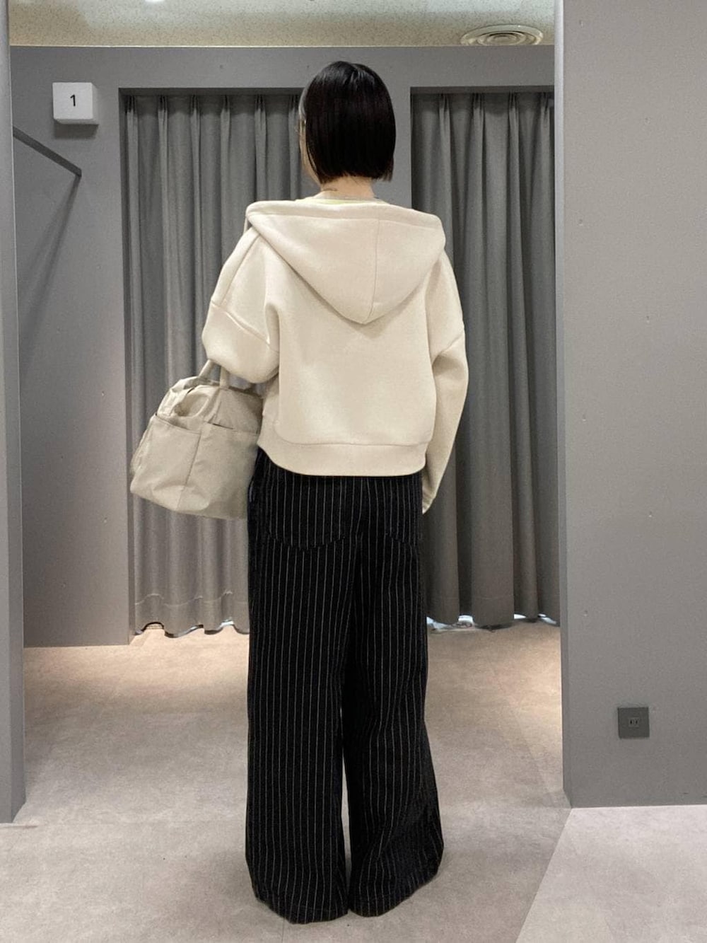 イエロー系のTシャツ/カットソー、ブラック系のサロペット/オーバーオール、ホワイト系のトートバッグを着用したレディースの冬コーディネートの3枚目の写真