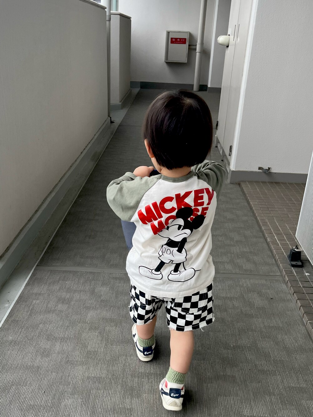 ホワイト系のTシャツ/カットソー、ブラック系のパンツ、ホワイト系のスニーカーを着用したキッズの夏コーディネートの3枚目の写真