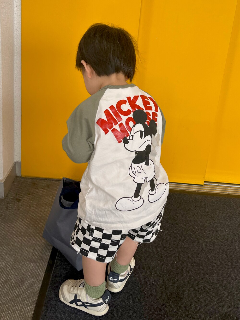 ホワイト系のTシャツ/カットソー、ブラック系のパンツ、ホワイト系のスニーカーを着用したキッズの夏コーディネートの2枚目の写真