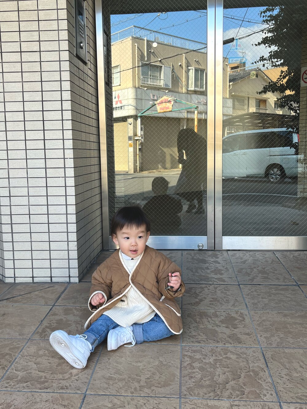 ブラウン系のジャケット/アウター、ブルー系のデニムパンツ、ホワイト系のスニーカーを着用したキッズの夏コーディネートの2枚目の写真