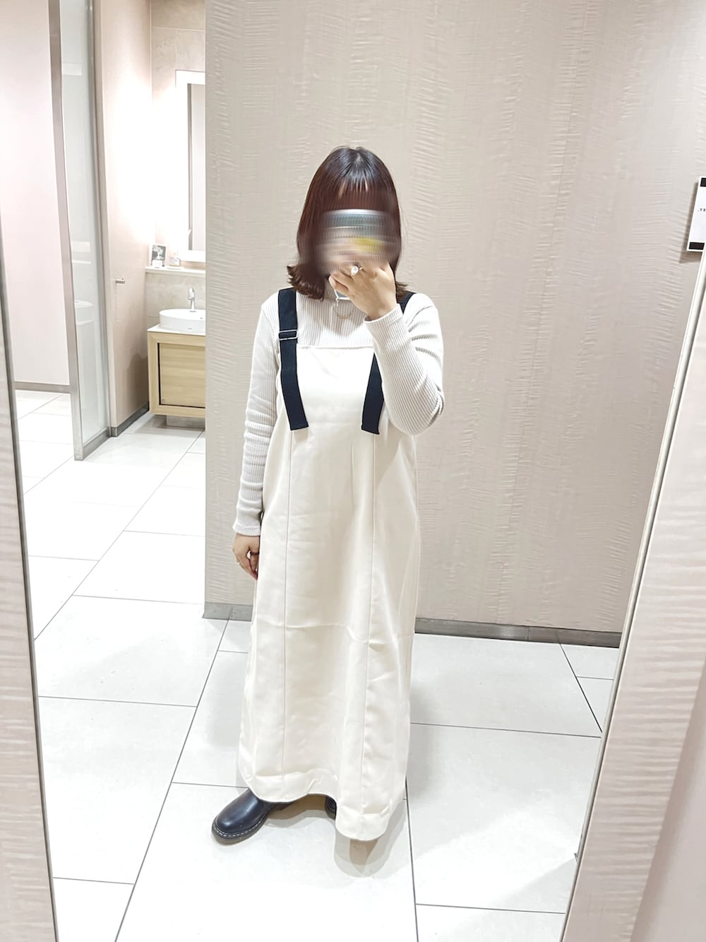 ホワイト系のトートバッグ、ベージュ系のカーディガン/ボレロ、ホワイト系のジャンパースカートを着用したレディースの春コーディネートの2枚目の写真