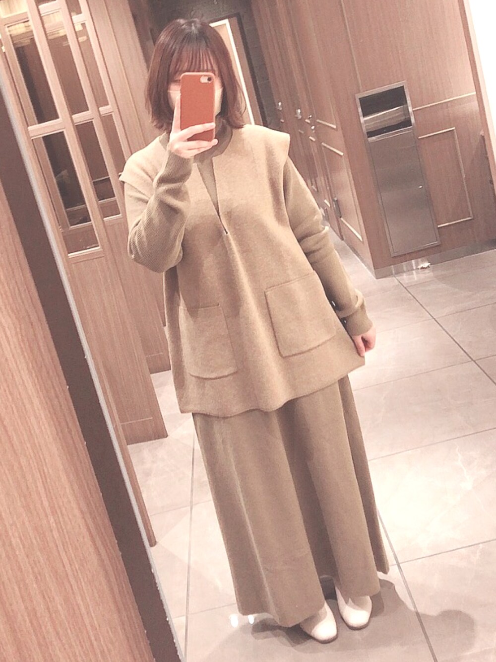 ホワイト系のムートンコート、ベージュ系のワンピース、ホワイト系のブーツを着用したレディースの春コーディネートの2枚目の写真