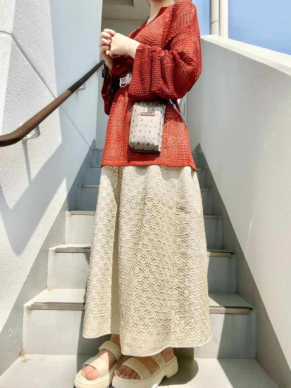 その他のショルダーバッグ、ベージュ系のスカート、ホワイト系のサンダルを着用したレディースの春コーディネートの2枚目の写真