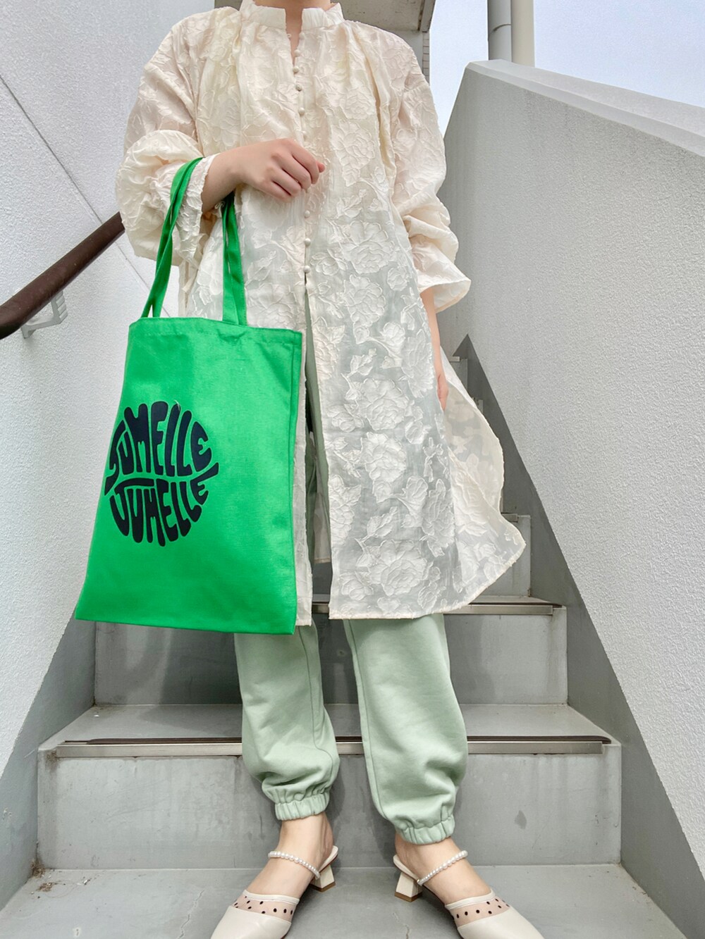 グリーン系のスウェットパンツ、ホワイト系のワンピース、ホワイト系のパンプスを着用したレディースの春コーディネートの2枚目の写真