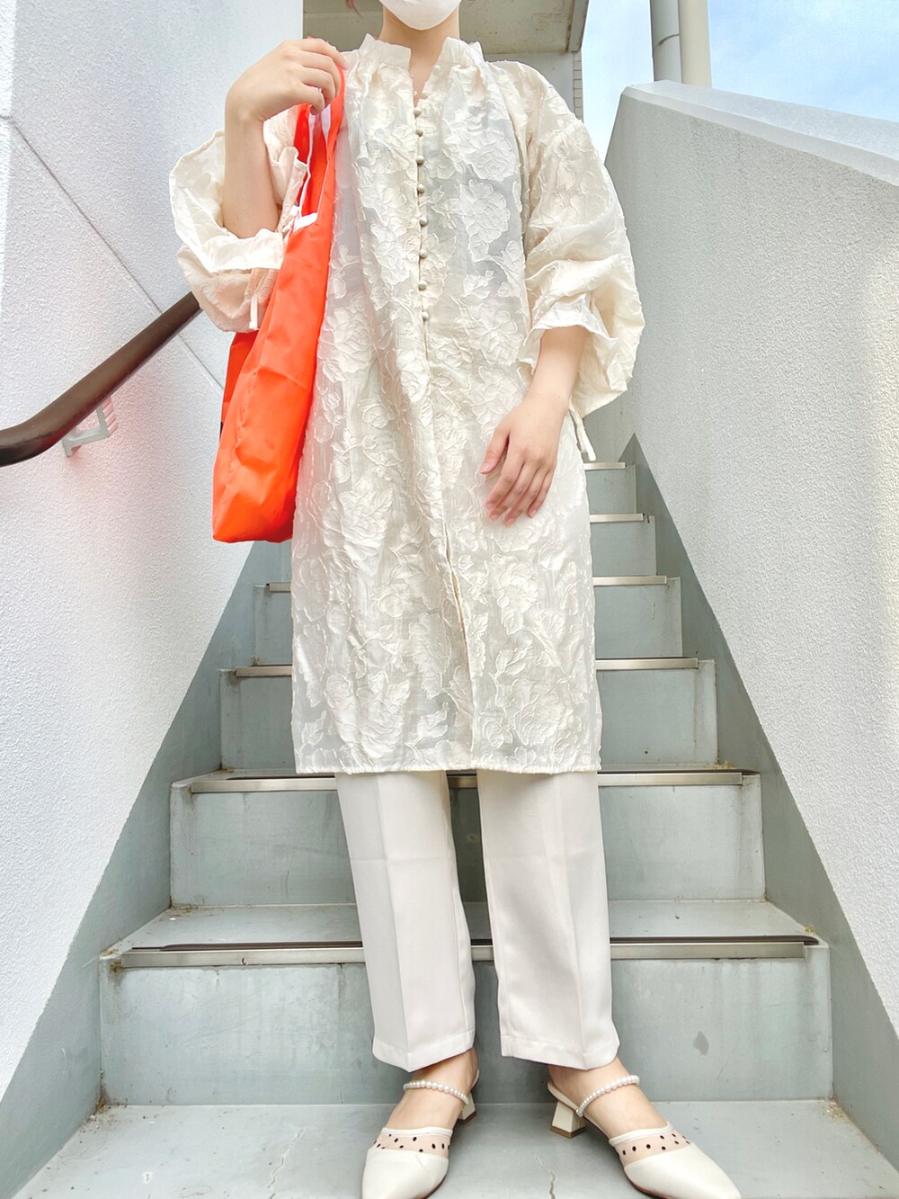 ホワイト系のパンプス、オレンジ系のエコバッグ/サブバッグ、ホワイト系のワンピースを着用したレディースの夏コーディネートの2枚目の写真