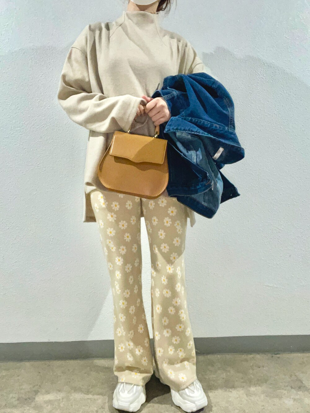 ブラウン系のハンドバッグ、ホワイト系のスニーカー、ベージュ系のその他パンツを着用したレディースの春コーディネートの2枚目の写真