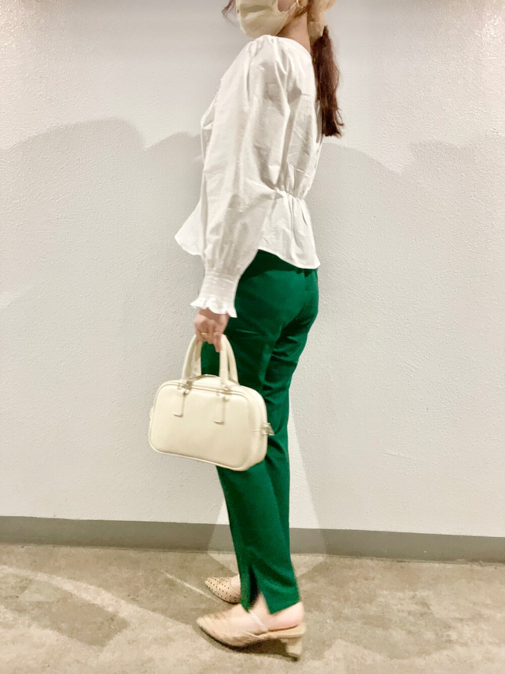 グリーン系のその他パンツ、ベージュ系のパンプス、ホワイト系のハンドバッグを着用したレディースの春コーディネートの3枚目の写真