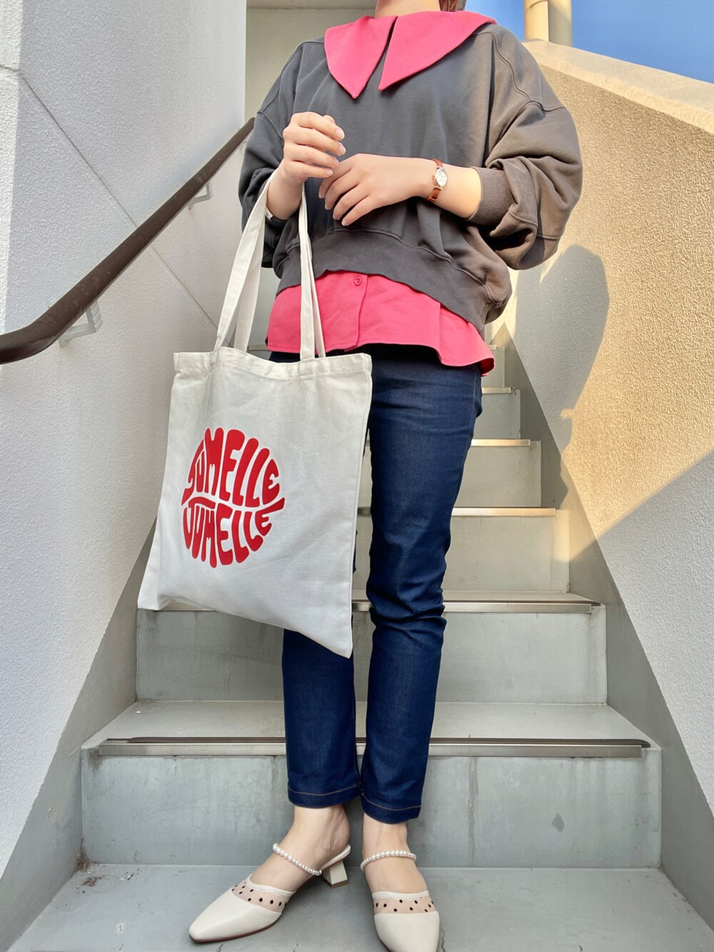 グレー系のスウェット、ピンク系のTシャツ/カットソー、ブルー系のデニムパンツを着用したレディースの春コーディネートの2枚目の写真