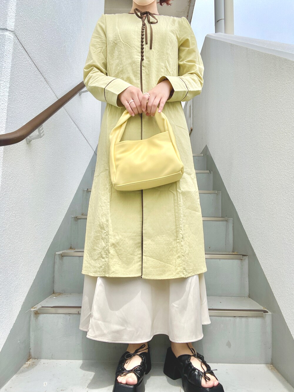 グリーン系のワンピース、ホワイト系のスカート、ブラック系のサンダルを着用したレディースの夏コーディネートの2枚目の写真