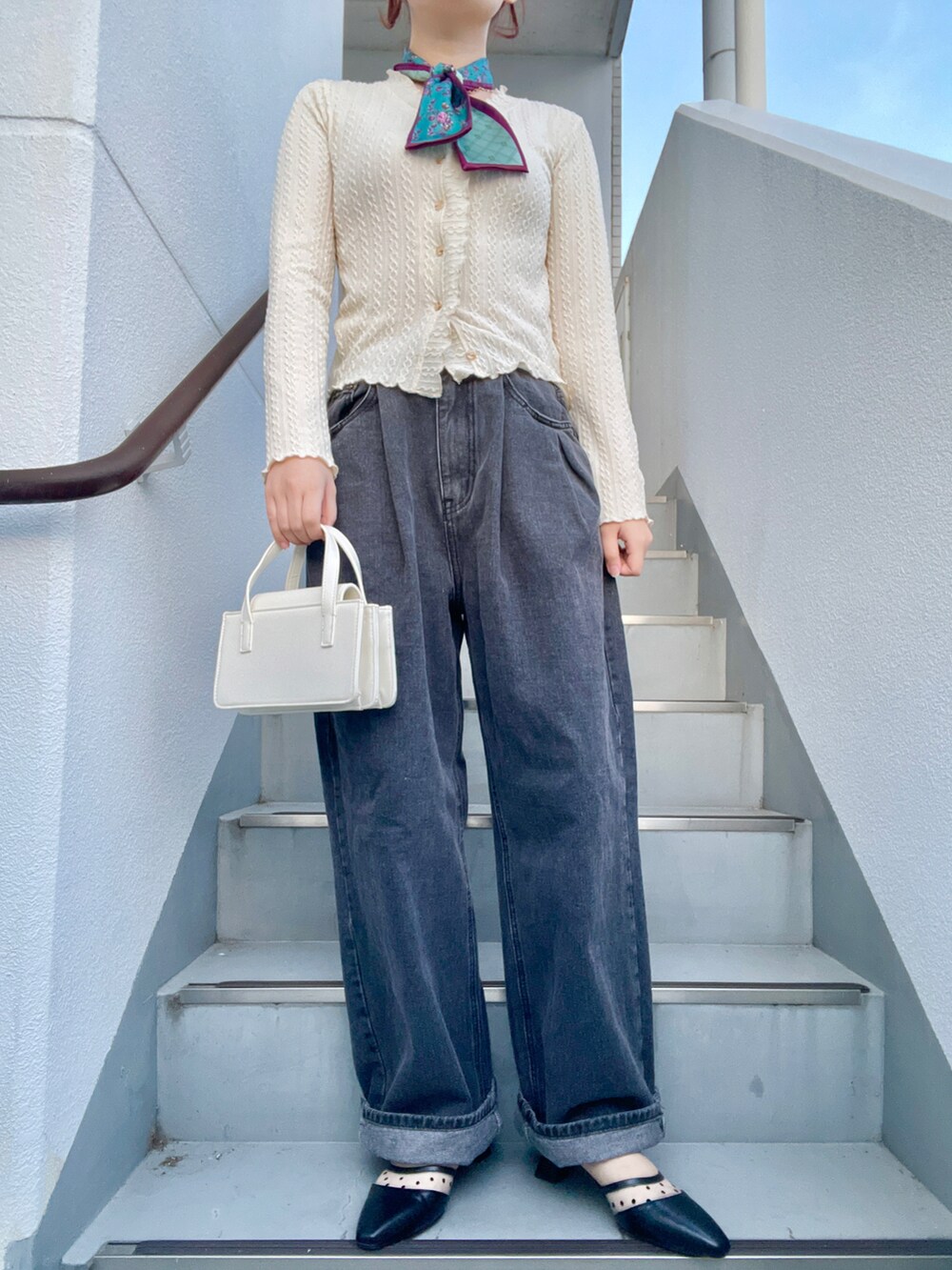 ベージュ系のカーディガン/ボレロ、ホワイト系のショルダーバッグ、ブラック系のデニムパンツを着用したレディースの春コーディネートの2枚目の写真