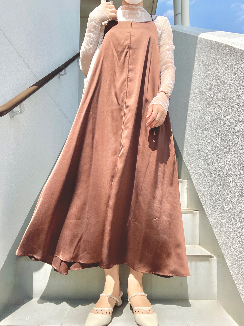 ブラウン系のワンピース、ベージュ系のトートバッグ、ホワイト系のパンプスを着用したレディースの夏コーディネートの2枚目の写真