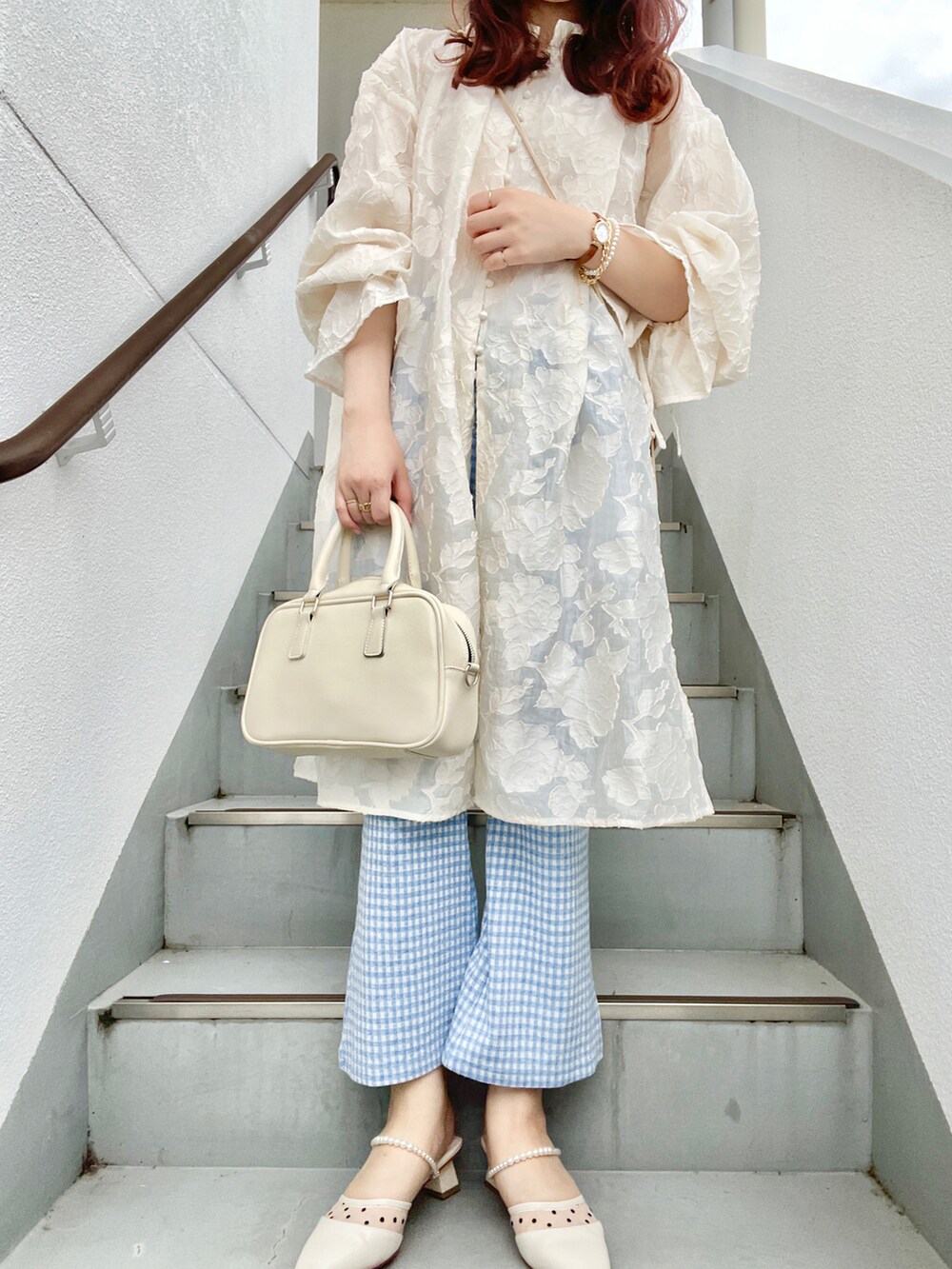 ホワイト系のハンドバッグ、ブルー系のその他パンツ、ホワイト系のパンプスを着用したレディースの春コーディネートの2枚目の写真