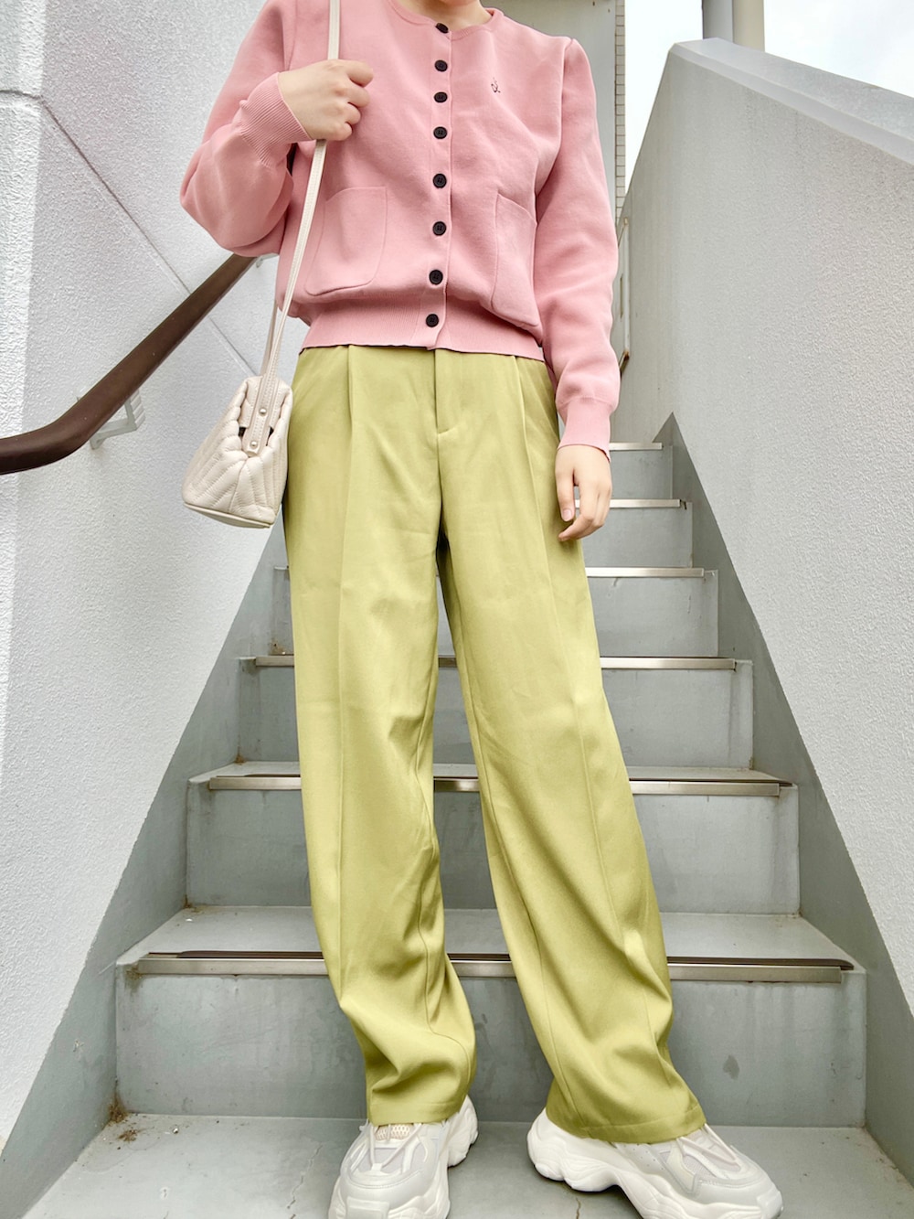 ピンク系のカーディガン/ボレロ、ホワイト系のショルダーバッグ、グリーン系のスラックスを着用したレディースの春コーディネートの2枚目の写真