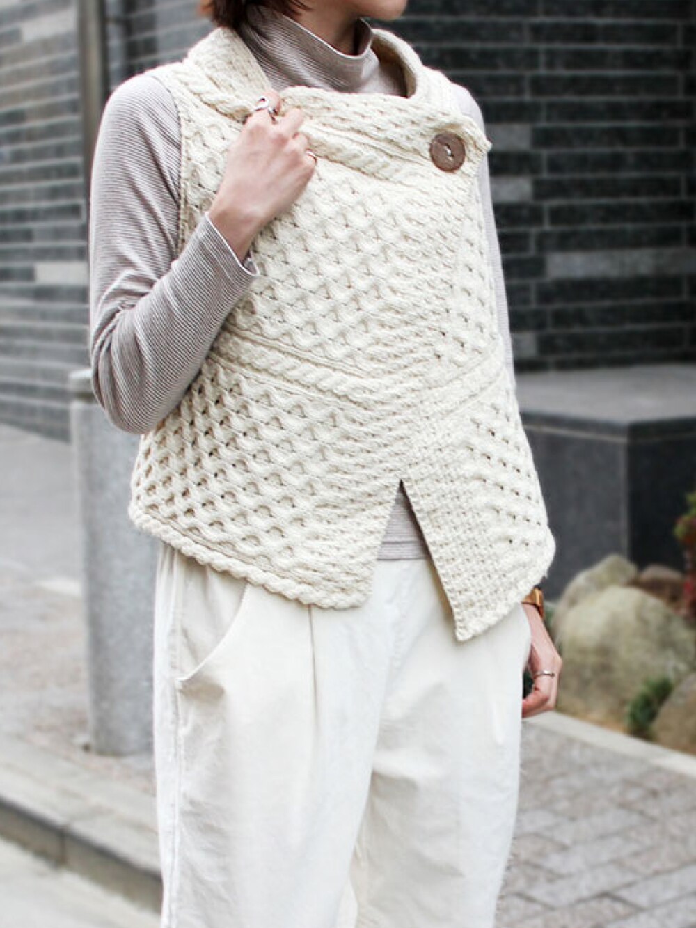 ホワイト系のパンツ、ホワイト系のニット/セーター、ベージュ系のTシャツ/カットソーを着用したレディースの春コーディネートの3枚目の写真