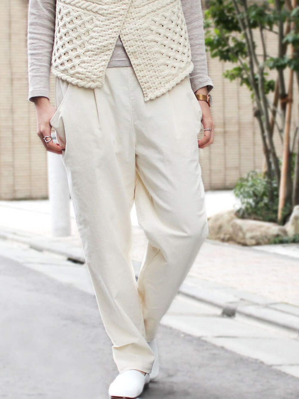 ホワイト系のパンツ、ホワイト系のニット/セーター、ベージュ系のTシャツ/カットソーを着用したレディースの春コーディネートの2枚目の写真