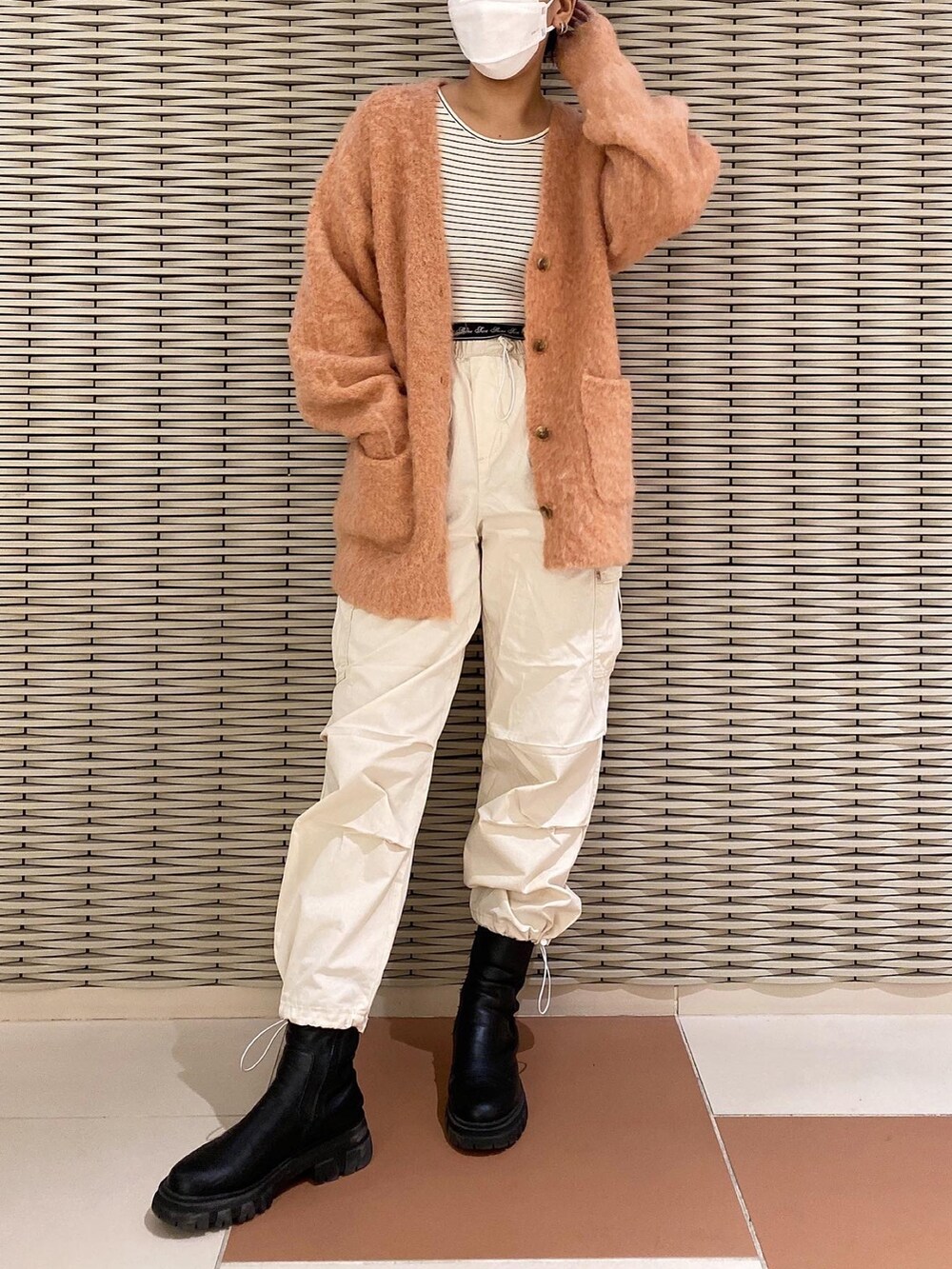 ブラック系のTシャツ/カットソー、オレンジ系のカーディガン/ボレロ、ホワイト系のカーゴパンツを着用したレディースの秋コーディネートの3枚目の写真