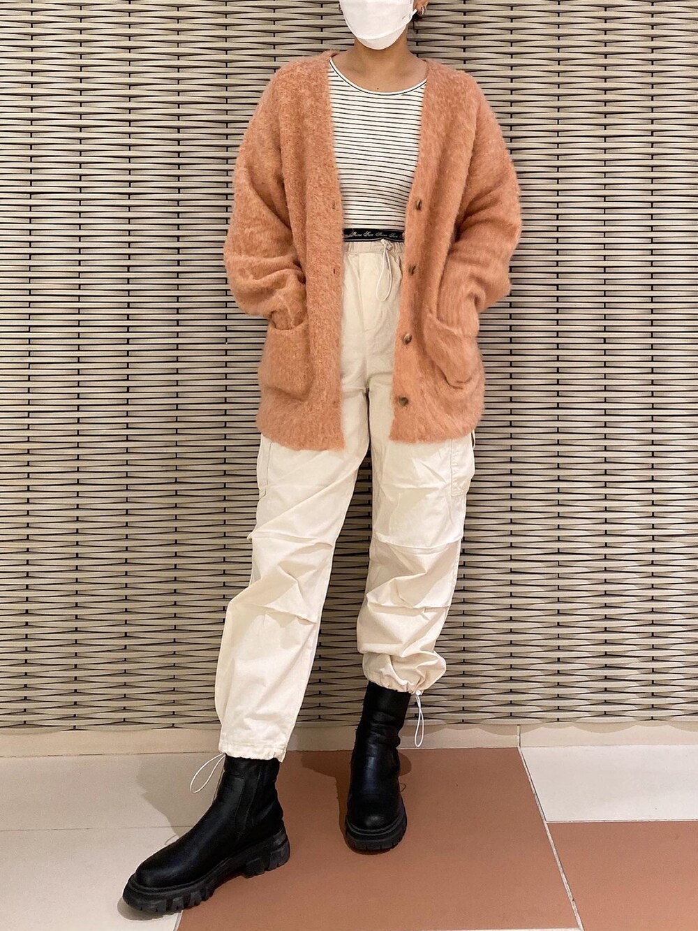 ブラック系のTシャツ/カットソー、オレンジ系のカーディガン/ボレロ、ホワイト系のカーゴパンツを着用したレディースの秋コーディネートの2枚目の写真