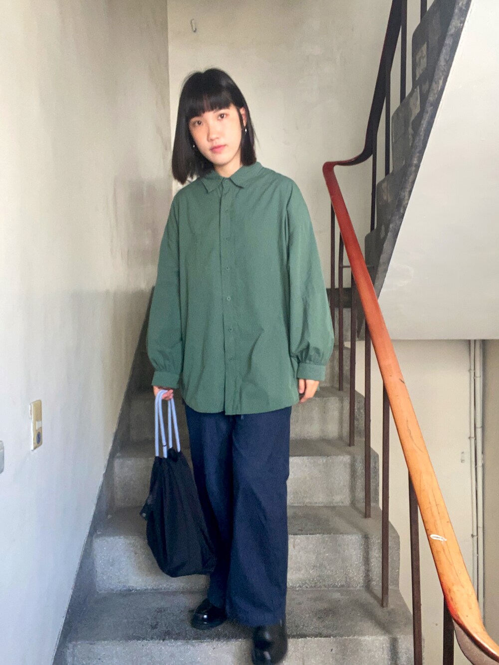 グリーン系のシャツ/ブラウス、ブラック系のショルダーバッグ、ブラック系のローファーを着用したレディースの冬コーディネートの2枚目の写真