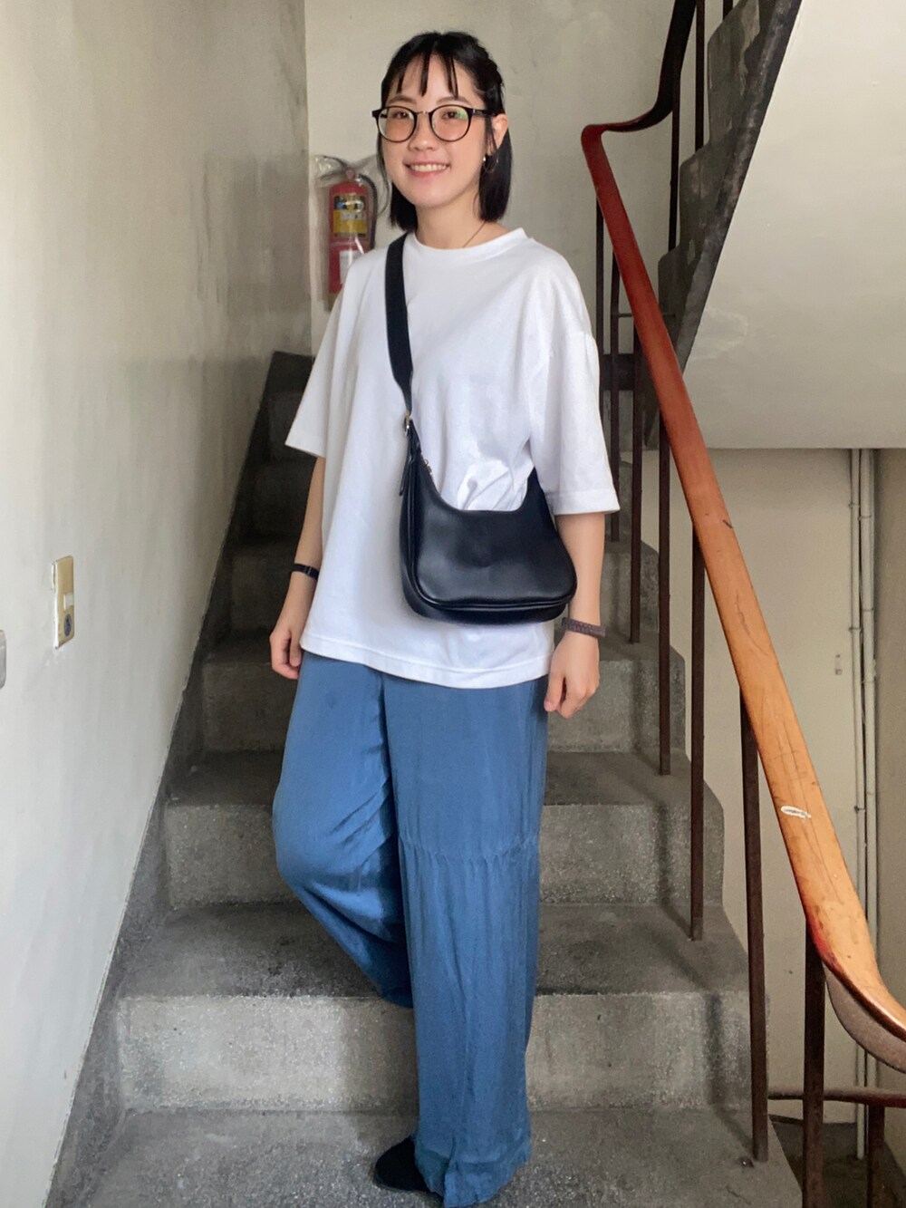 ブラック系のローファー、ブルー系のチノパンツ、ホワイト系のTシャツ/カットソーを着用したレディースの春コーディネートの2枚目の写真