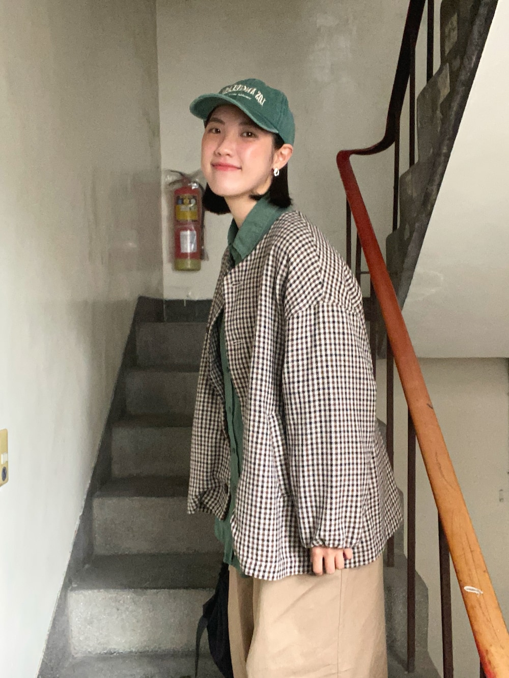 ベージュ系のチノパンツ、グレー系のスニーカー、グリーン系のシャツ/ブラウスを着用したレディースの春コーディネートの4枚目の写真