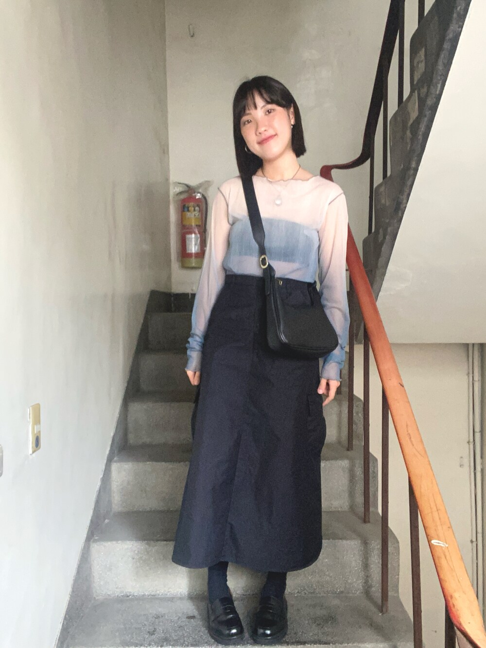 ブラック系のスカートを着用したレディースの夏コーディネートの2枚目の写真