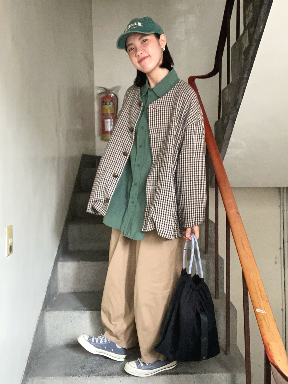 ベージュ系のチノパンツ、グレー系のスニーカー、グリーン系のシャツ/ブラウスを着用したレディースの春コーディネートの2枚目の写真