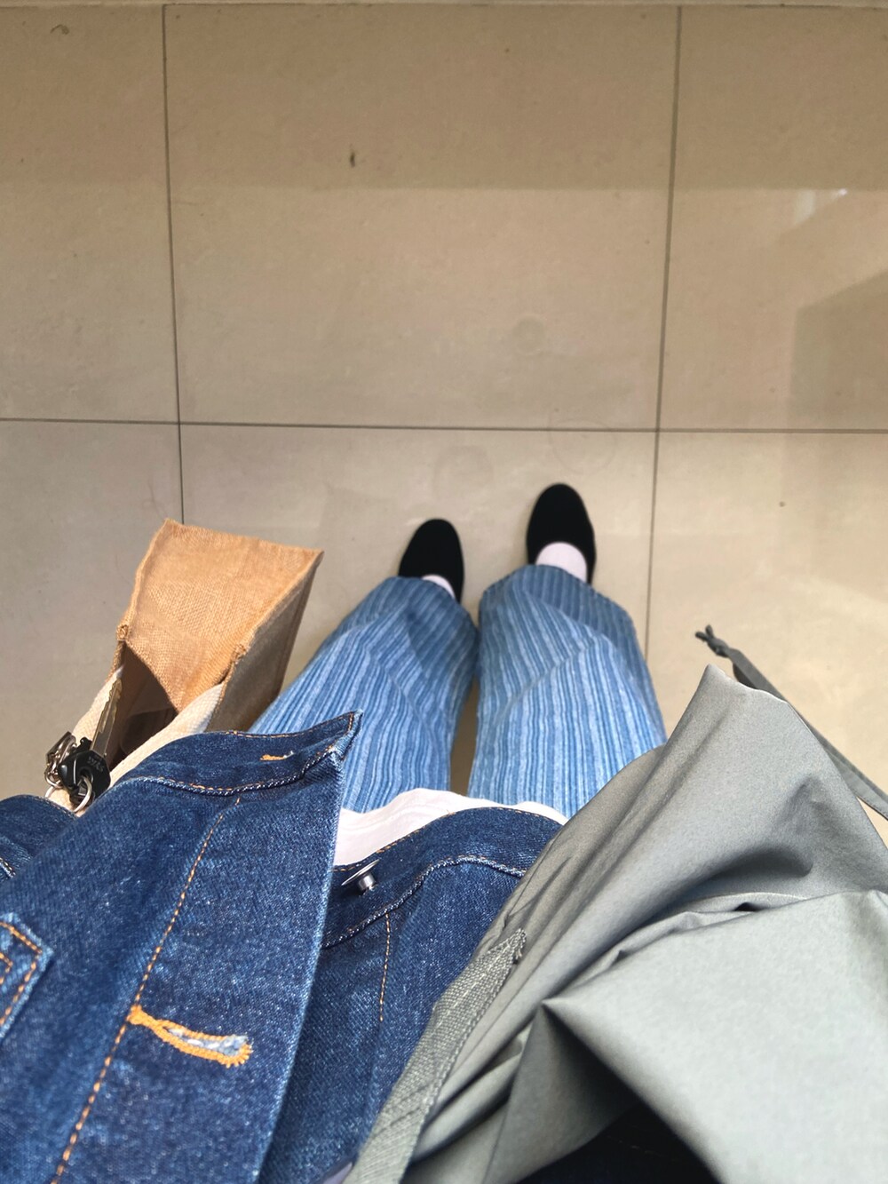 ブルー系のデニムパンツ、グリーン系のバックパック/リュック、ベージュ系のかごバッグを着用したレディースの冬コーディネートの2枚目の写真