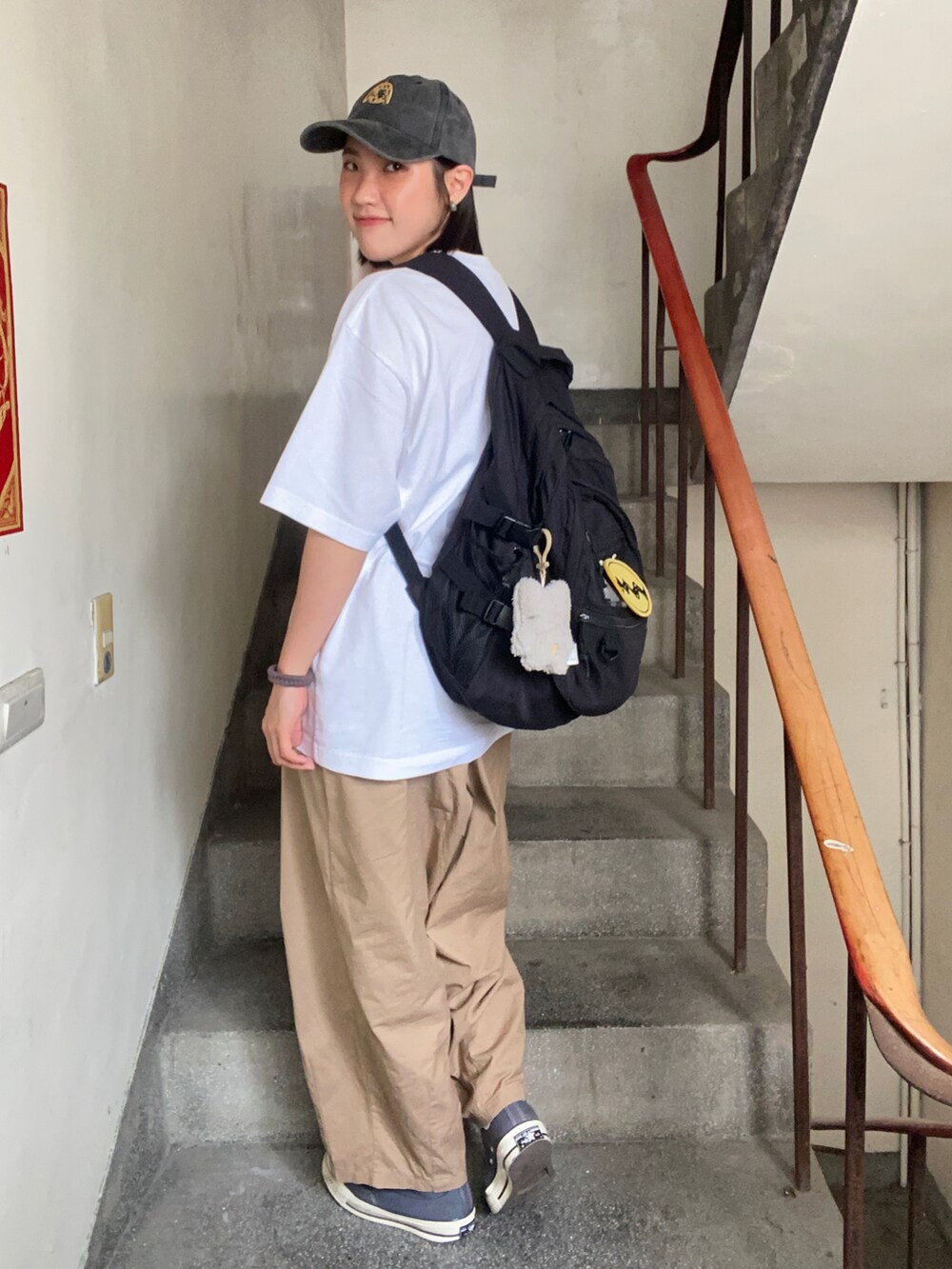 ホワイト系のTシャツ/カットソー、ブラウン系のチノパンツ、グレー系のスニーカーを着用したレディースの春コーディネートの3枚目の写真