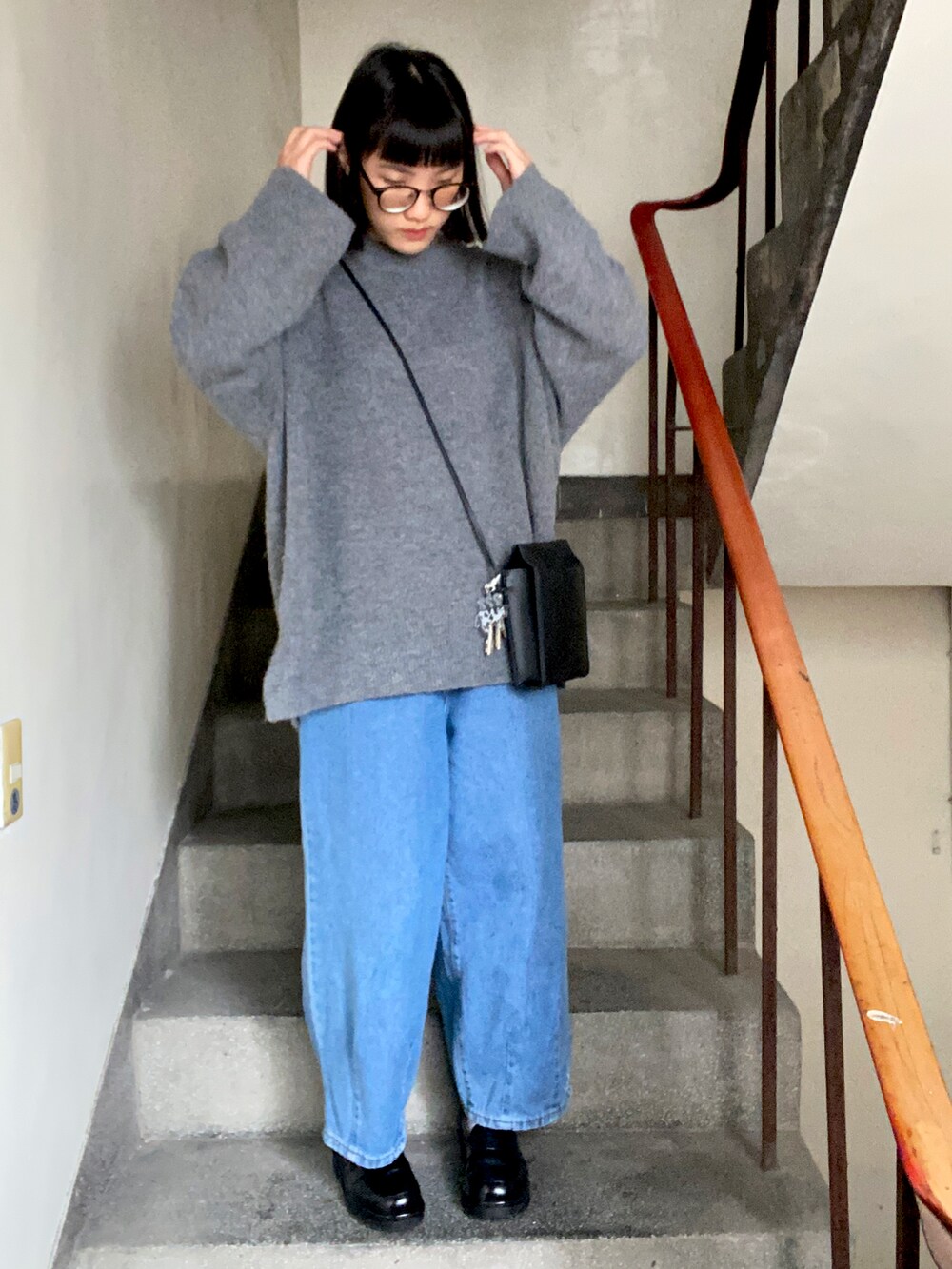 ブラック系のショルダーバッグ、ブラック系のローファーを着用したレディースの冬コーディネートの2枚目の写真