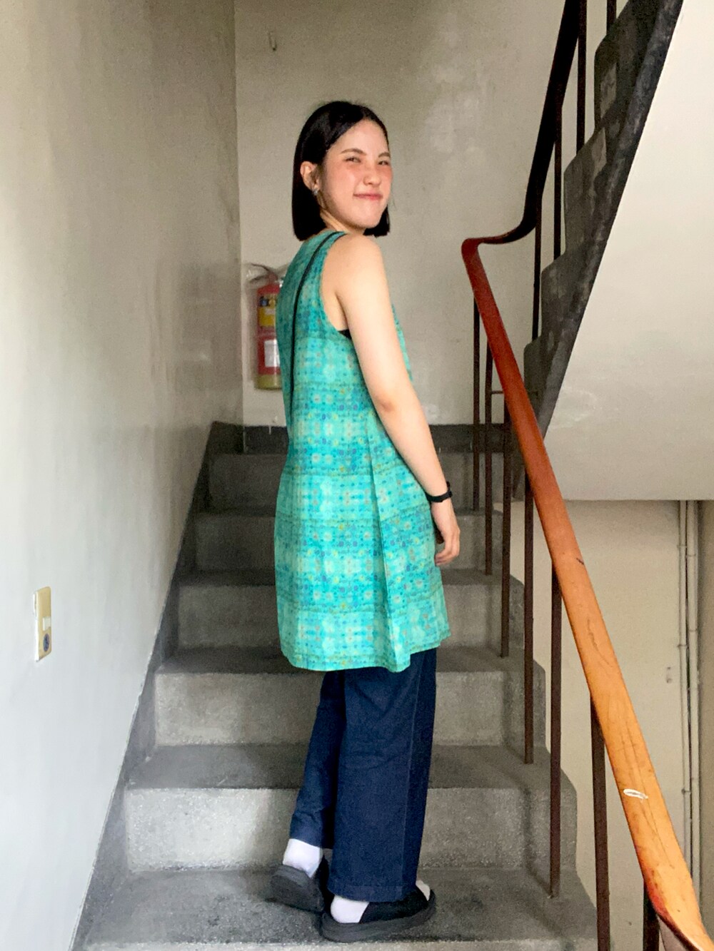 ブラック系のショルダーバッグ、ブルー系のデニムパンツ、グレー系のソックス/靴下を着用したレディースの春コーディネートの2枚目の写真