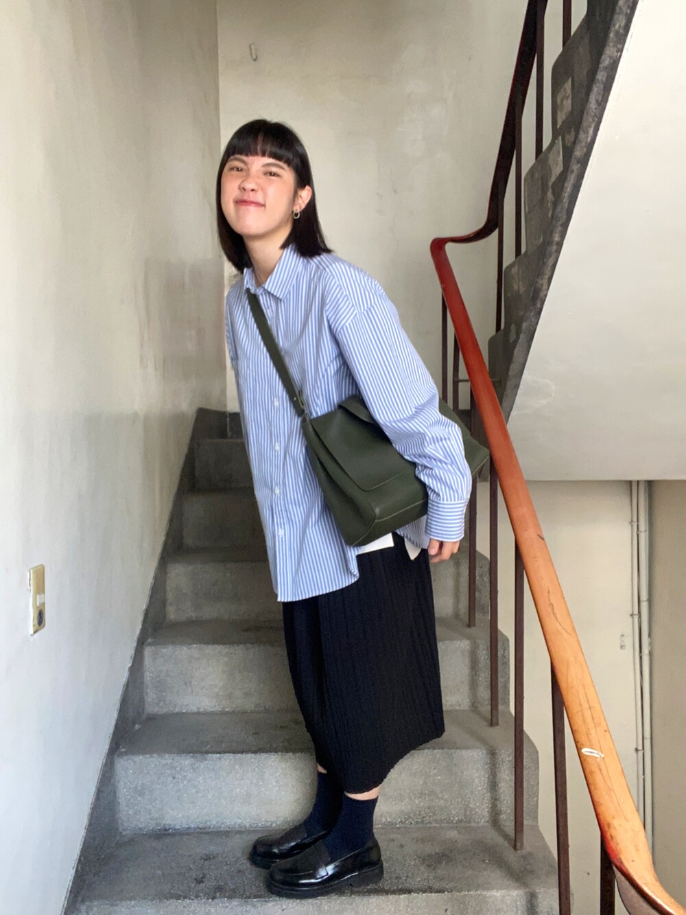 グリーン系のショルダーバッグを着用したレディースの春コーディネートの2枚目の写真