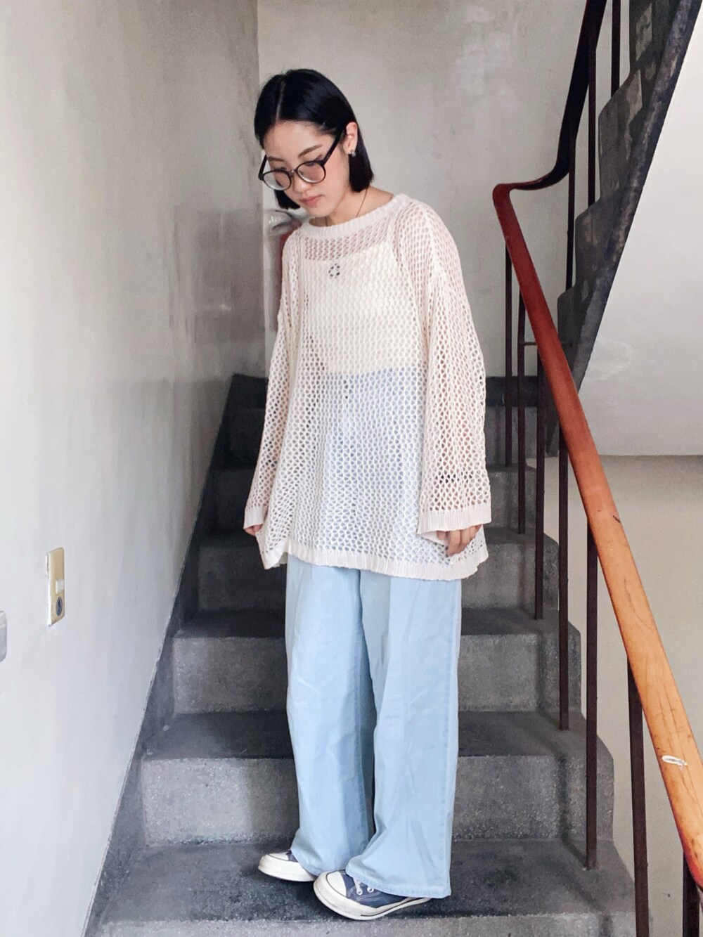 ブルー系のデニムパンツ、グレー系のスニーカーを着用したレディースの春コーディネートの2枚目の写真