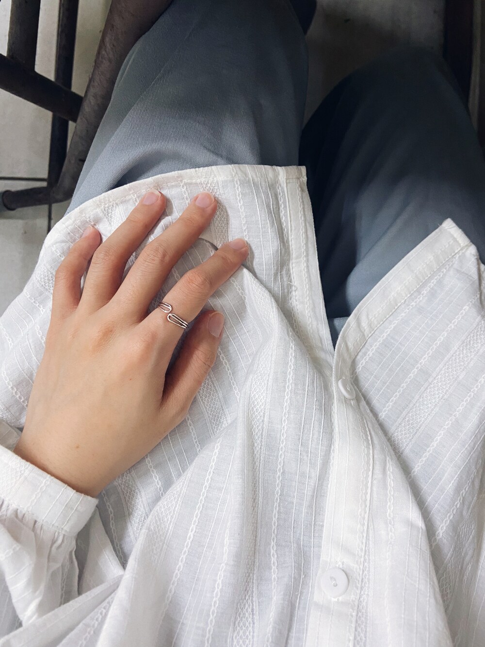 ベージュ系のショルダーバッグ、ベージュ系のスニーカー、ブルー系のチノパンツを着用したレディースの春コーディネートの3枚目の写真