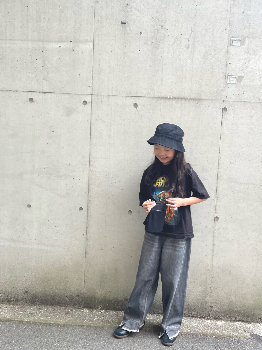 グレー系のデニムパンツ、ブラック系のスニーカー、ブラック系のTシャツ/カットソーを着用したキッズの春コーディネートの3枚目の写真